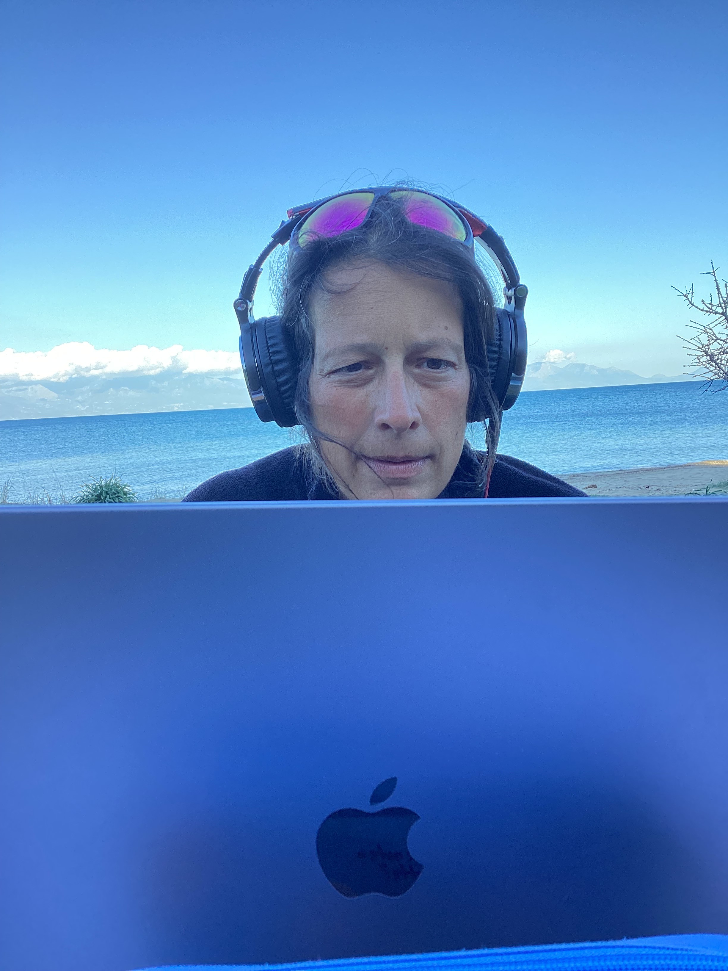 Marie-Ève avec son casque audio devant son ordinateur, en bord de mer