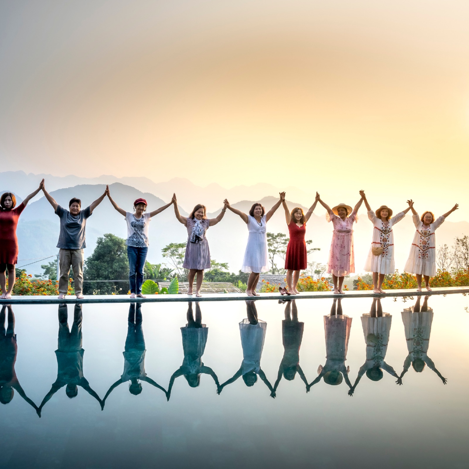 Groupe de femmes réunies, mains levées ensemble, symbole de communauté